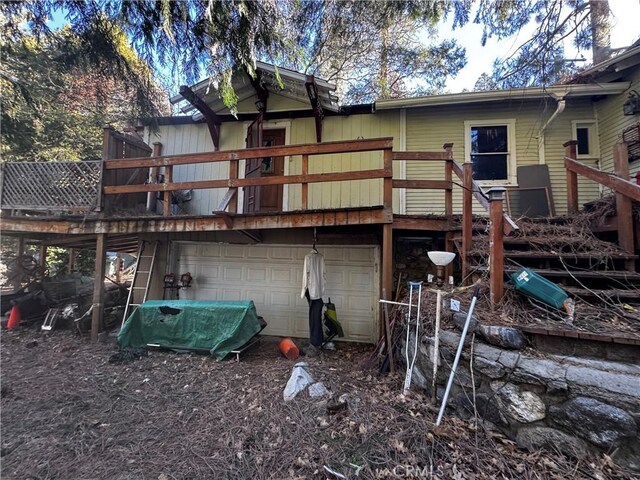 back of house with a deck and an attached garage