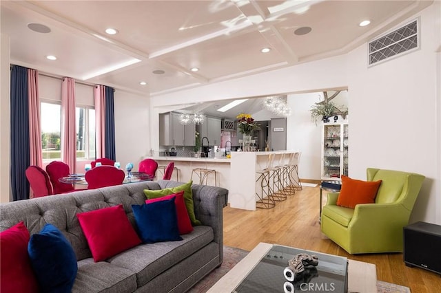 living room with beamed ceiling, coffered ceiling, hardwood / wood-style floors, and a chandelier