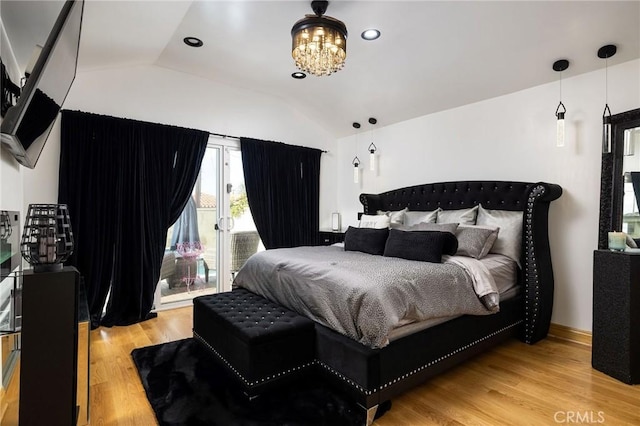 bedroom featuring lofted ceiling, access to exterior, a notable chandelier, and light wood-type flooring