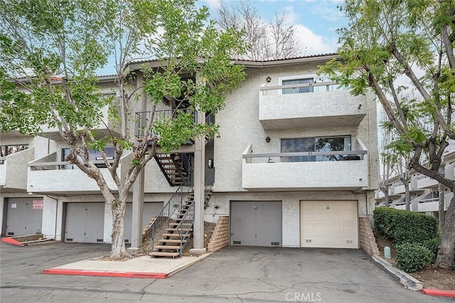 multi unit property featuring a garage and a balcony