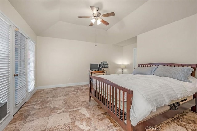 bedroom with ceiling fan, a tray ceiling, multiple windows, and access to outside