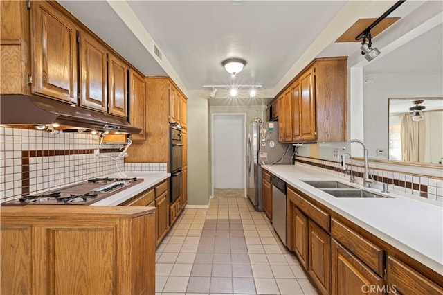 kitchen with sink, light tile patterned floors, stainless steel appliances, and backsplash