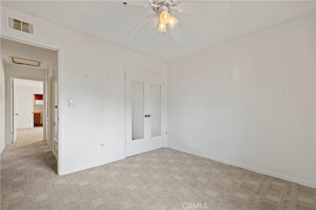 carpeted spare room with ceiling fan and a textured ceiling