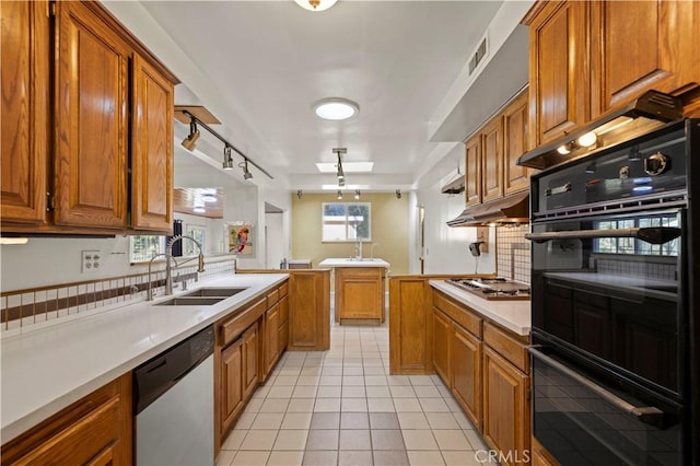 kitchen featuring light tile patterned flooring, tasteful backsplash, sink, kitchen peninsula, and stainless steel appliances