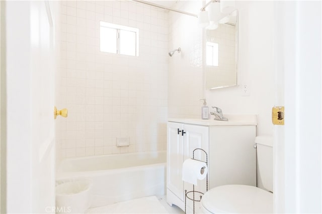 full bathroom with tiled shower / bath, vanity, and toilet