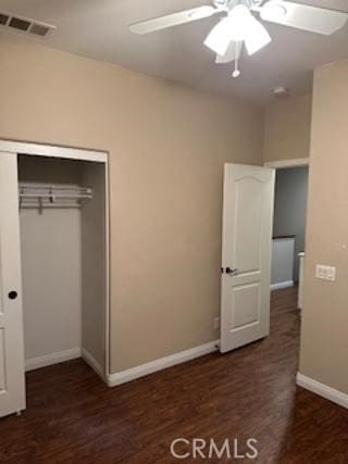 unfurnished bedroom featuring baseboards, visible vents, a ceiling fan, dark wood finished floors, and a closet