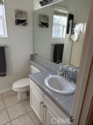 bathroom featuring baseboards, vanity, toilet, and tile patterned floors