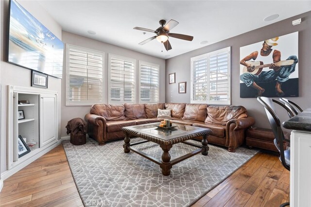 living area featuring light wood-style flooring and ceiling fan