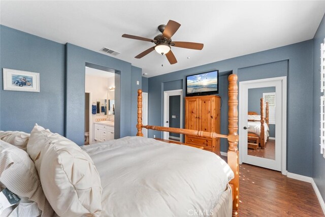 bedroom featuring ceiling fan, visible vents, wood finished floors, baseboards, and connected bathroom