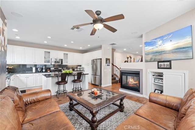 22 Arlington St, Ladera Ranch, CA 92694 - living room featuring light wood-style floors, ceiling fan, recessed lighting, and a glass covered fireplace