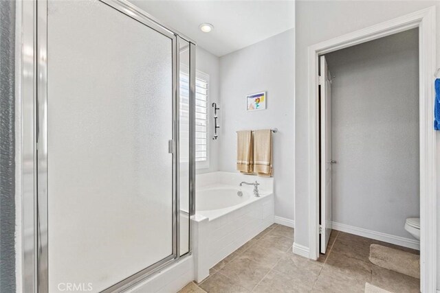 full bathroom with toilet, tile patterned floors, baseboards, a shower stall, and a garden tub
