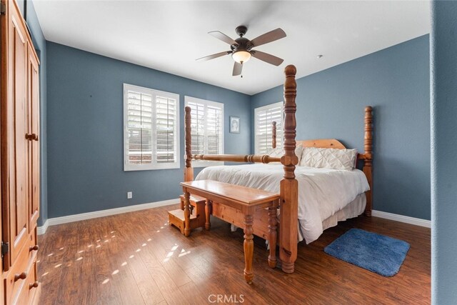 bedroom featuring a ceiling fan, baseboards, and wood finished floors