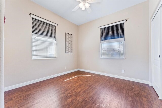spare room featuring baseboards, ceiling fan, and wood finished floors