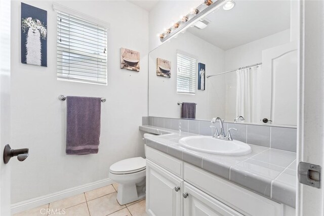 full bathroom featuring tile patterned flooring, vanity, toilet, baseboards, and a shower with curtain