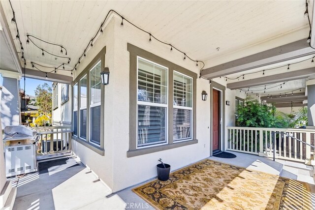 property entrance featuring covered porch and stucco siding