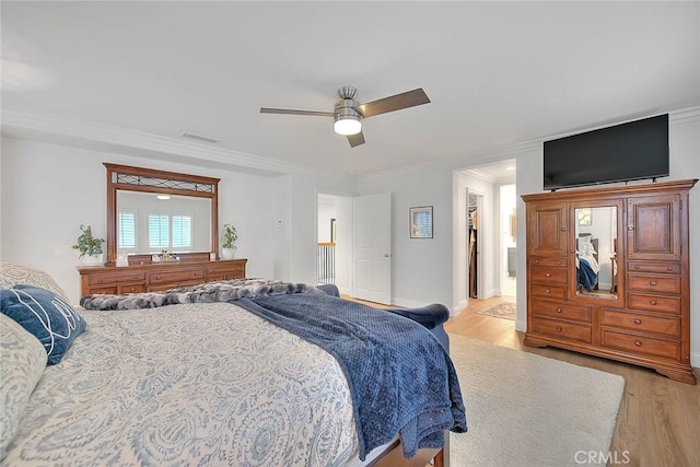 bedroom with ornamental molding, ceiling fan, and light wood-type flooring