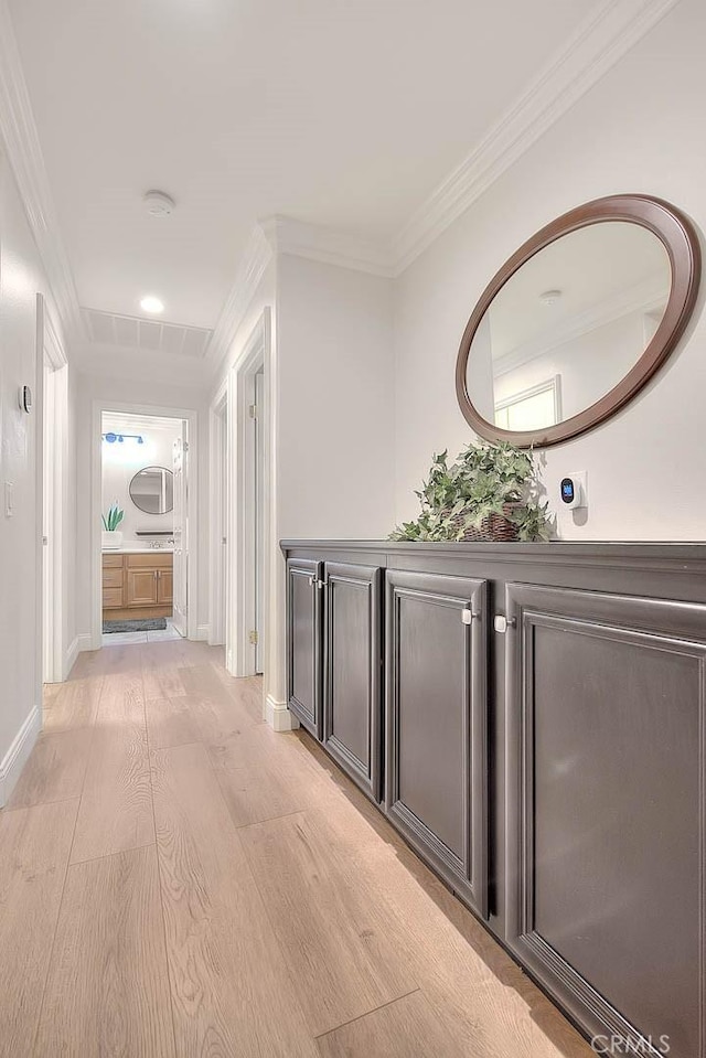 hallway featuring ornamental molding and light hardwood / wood-style floors