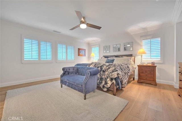 bedroom featuring crown molding, light hardwood / wood-style floors, and ceiling fan