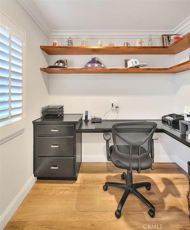 office featuring crown molding, built in desk, and light hardwood / wood-style floors