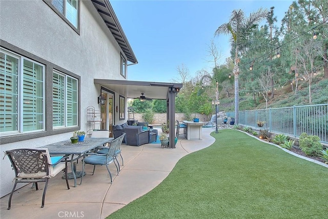 view of yard featuring ceiling fan, outdoor lounge area, and a patio