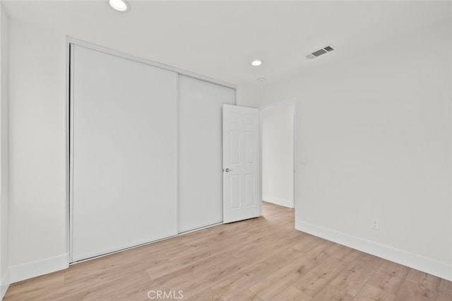 unfurnished bedroom with a closet and light hardwood / wood-style flooring