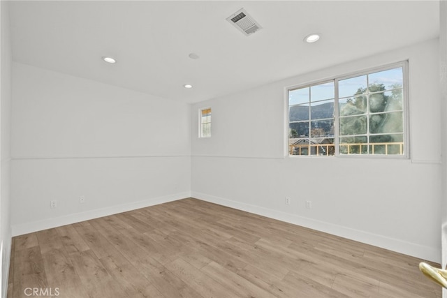 spare room with light wood finished floors, baseboards, visible vents, and recessed lighting