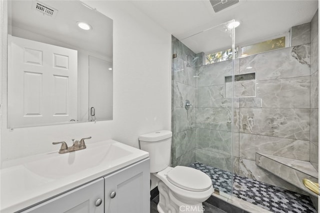 bathroom featuring vanity, toilet, and a shower with shower door