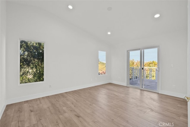 unfurnished room with lofted ceiling and light hardwood / wood-style floors