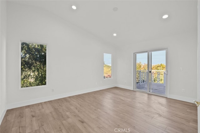 spare room with recessed lighting, lofted ceiling, baseboards, and wood finished floors