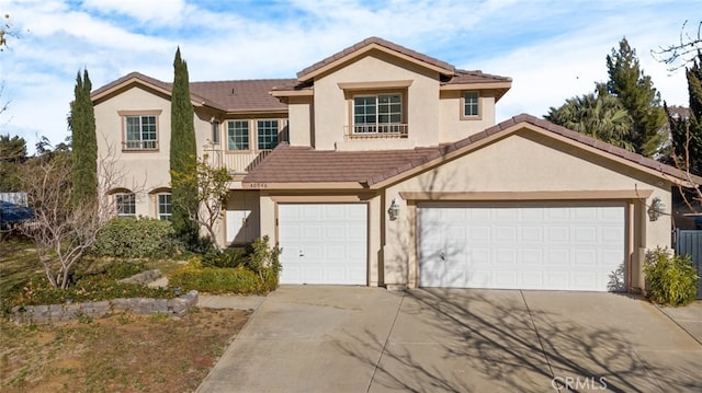 view of front of house with concrete driveway, a tile roof, and stucco siding