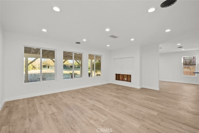 unfurnished living room with light wood-style flooring, recessed lighting, a fireplace, visible vents, and baseboards