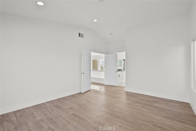 spare room featuring baseboards, visible vents, light wood-type flooring, high vaulted ceiling, and recessed lighting