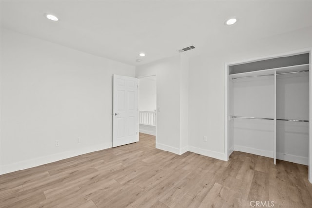 unfurnished bedroom featuring a closet and light hardwood / wood-style flooring