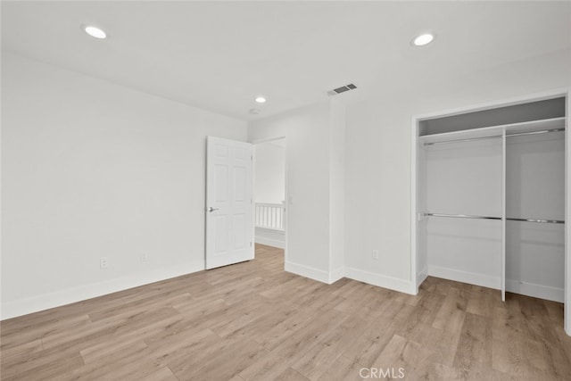 unfurnished bedroom featuring recessed lighting, a closet, visible vents, and light wood-style flooring