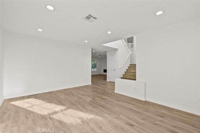 empty room featuring recessed lighting, visible vents, stairway, wood finished floors, and baseboards