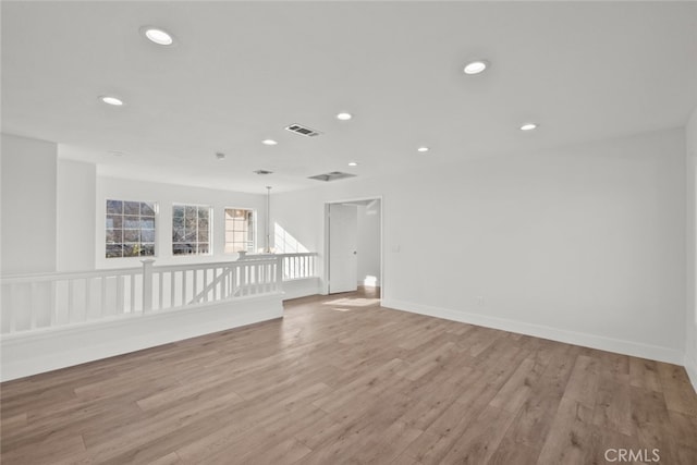 empty room featuring baseboards, light wood finished floors, visible vents, and recessed lighting