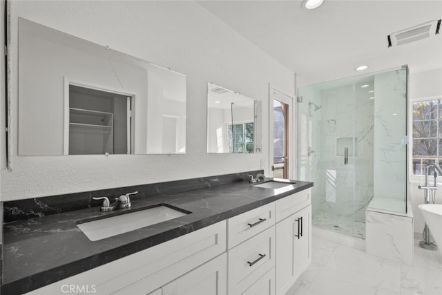 bathroom featuring marble finish floor, a marble finish shower, visible vents, and a sink