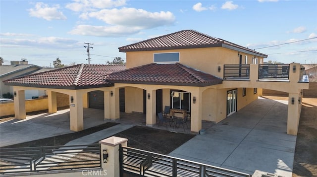 rear view of house featuring a balcony and a patio area