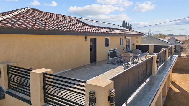 back of house featuring a patio and solar panels