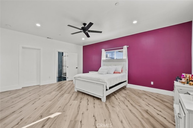 bedroom with ceiling fan, light hardwood / wood-style floors, and ensuite bath