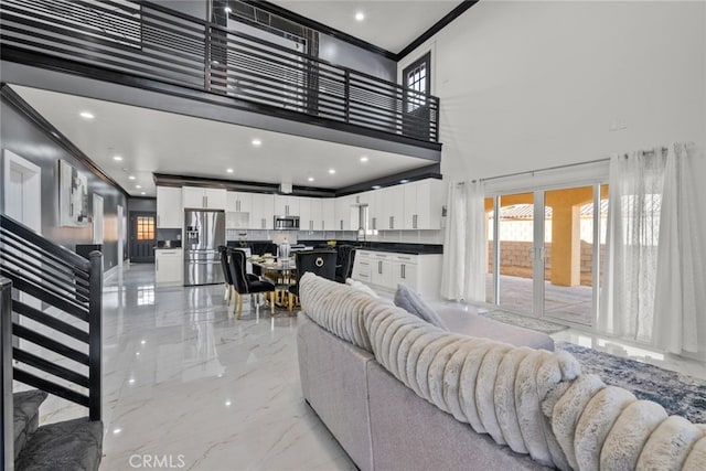 living room featuring ornamental molding and a high ceiling