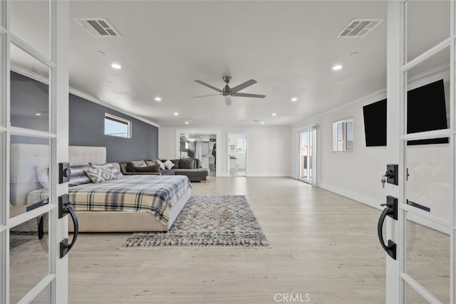 bedroom with ornamental molding, light wood-type flooring, and french doors