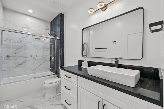 full bathroom featuring vanity, combined bath / shower with glass door, and toilet