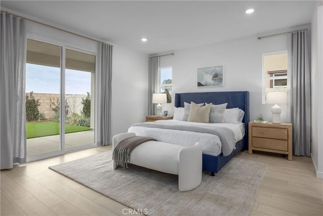 bedroom with access to exterior, light hardwood / wood-style floors, and multiple windows