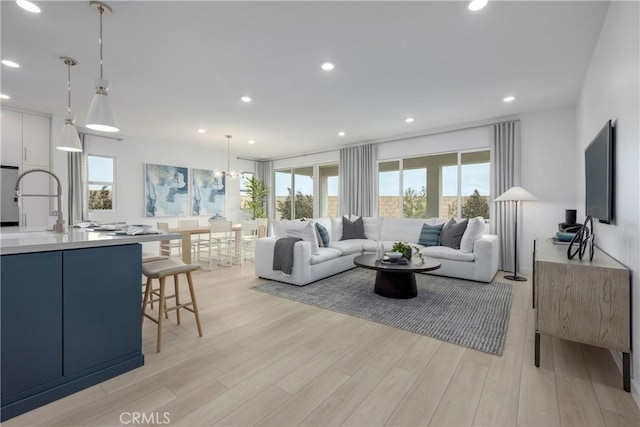 living room featuring sink and light hardwood / wood-style flooring