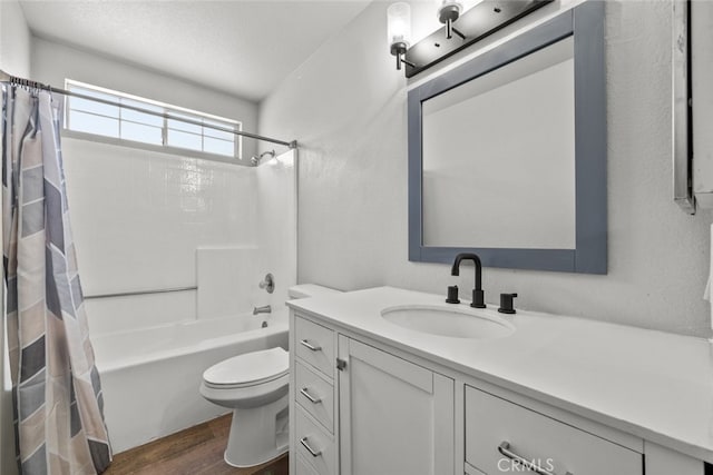 full bathroom with toilet, a textured ceiling, vanity, shower / bath combo with shower curtain, and hardwood / wood-style floors