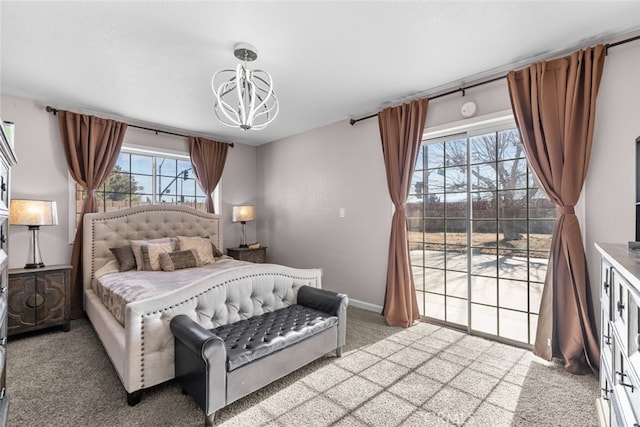 bedroom featuring access to exterior, a chandelier, and carpet