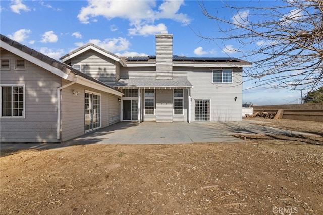 back of house featuring a patio area and solar panels