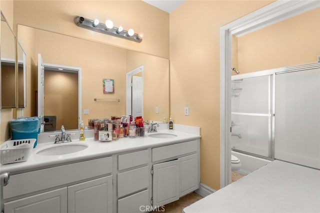 full bathroom featuring vanity, enclosed tub / shower combo, and toilet