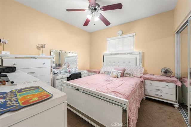 bedroom with ceiling fan and dark colored carpet